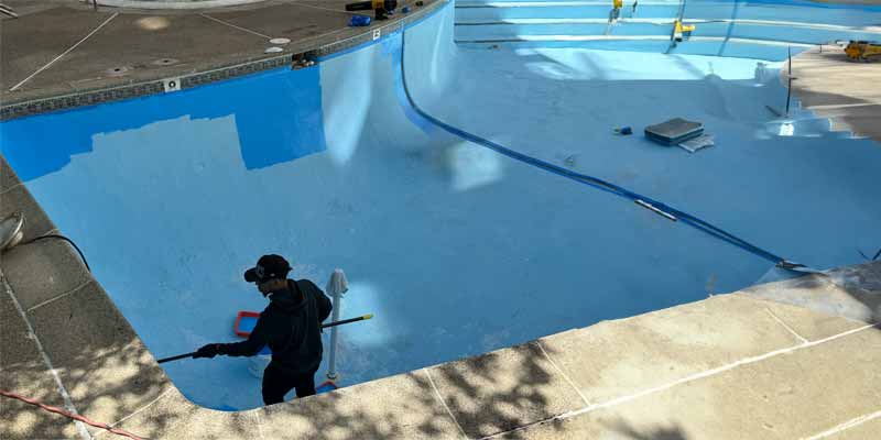 man renovating an inground pool